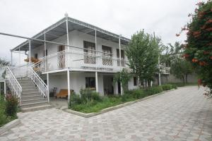 ein großes weißes Gebäude mit einer Treppe und einer Terrasse in der Unterkunft Guest House Nona in Kutaissi