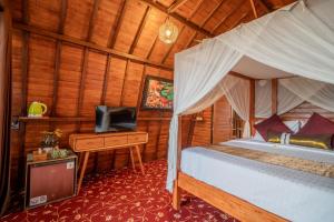 a bedroom with a bed and a tv in a room at Mai Mucuk Lumbung in Canggu