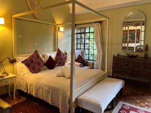 a bedroom with a bed with a four post canopy at Hob House in Nairobi