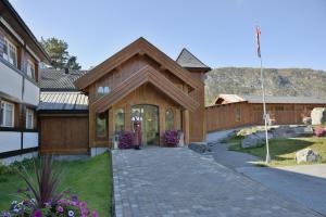 een groot houten huis met een stenen oprit bij HERMON HØYFJELLSSENTER in Skoro