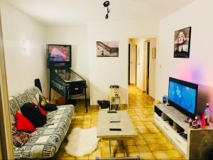 uma sala de estar com um sofá e uma televisão de ecrã plano em Beautiful house garden-floor with sea view & 10 min walk em Vallauris