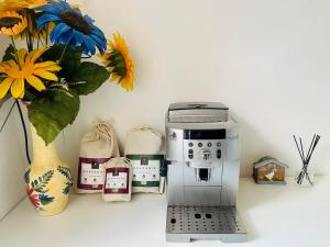 eine Kaffeemaschine auf einer Theke neben einer Vase mit Blumen in der Unterkunft Beautiful house garden-floor with sea view & 10 min walk in Vallauris