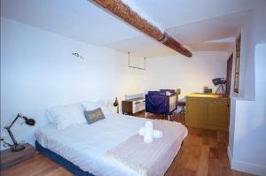 - une chambre avec un grand lit blanc et un bureau dans l'établissement Apartment Cabanel, à Montpellier