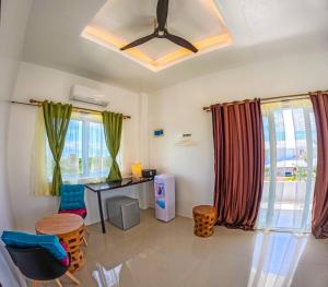 a living room with a table and chairs and windows at Divers Lodge Plumeria in Moalboal