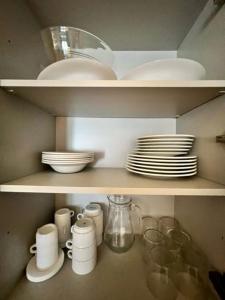 a shelf with plates and cups and dishes on it at Aparthotel El Serch in Andorra la Vella