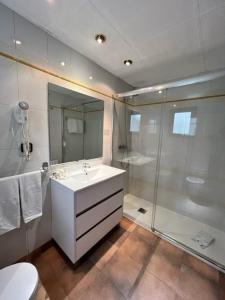 ein Badezimmer mit einem weißen Waschbecken und einer Dusche in der Unterkunft Aparthotel El Serch in Andorra la Vella