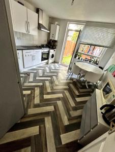 a kitchen with a wooden floor with a table at The Yellow House in London