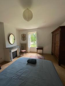 een slaapkamer met een groot bed en een open haard bij Villa Josephine in Quinsac