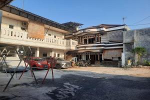een groot gebouw met auto's geparkeerd voor het bij OYO Life 93160 Kost Jenny Karawang in Karawang
