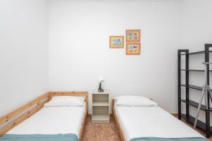 Habitación con 2 camas individuales y paredes blancas. en Lovely Village 3BR Sea Views Home - Beach nearby, en Agüimes
