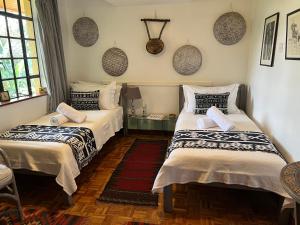two beds sitting in a room with at Hob House in Nairobi