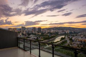 een balkon met uitzicht op de stad bij zonsondergang bij Sky by the river in Tbilisi City