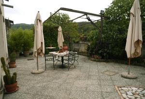 un patio con sombrillas, mesa y sillas en LA CASA SUL LARA, en Santo Stefano di Rogliano