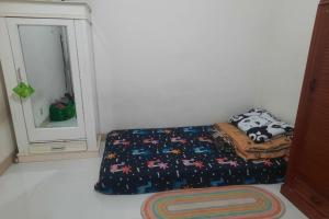 1 dormitorio con cama y espejo en OYO Life 93160 Kost Jenny Karawang, en Karawang
