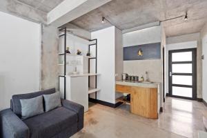 a living room with a couch and a sink at Balissimo Apartment by Hombali in Seminyak