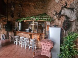 a bar with stools and a refrigerator in a room at Royal Villa Guesthouse in Brakpan