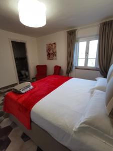 una camera da letto con un grande letto bianco con una coperta rossa di Vinci - Idea Resort - Tuscany a Vinci