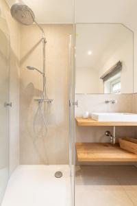 uma casa de banho com um chuveiro, um lavatório e um espelho. em Familienhaus am Meer em Dornum