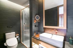 a bathroom with a sink and a toilet and a mirror at 北京悦明元星空白塔景观四合院民宿 in Beijing