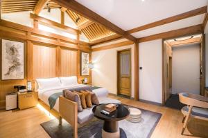 a bedroom with a bed and a couch and a table at 北京悦明元星空白塔景观四合院民宿 in Beijing
