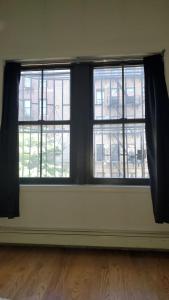 Cette chambre vide dispose de 2 fenêtres et de parquet. dans l'établissement Fawlty Towers, à Brooklyn