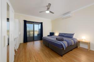 ein weißes Schlafzimmer mit einem Bett und einem Fenster in der Unterkunft 120 Madaffari Drive in Exmouth