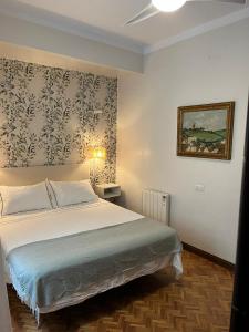 ein Schlafzimmer mit einem Bett und einem Wandgemälde in der Unterkunft Casa en la Corredera in Vejer de la Frontera