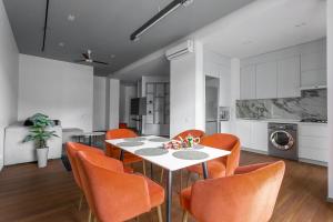 a dining room with a white table and orange chairs at Boulevard 181 in Tashkent