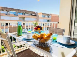 a table with baskets of bread and fruit on a balcony at Très bel appartement face au port Santa -Piscine in Saint-Raphaël