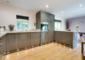 a kitchen with stainless steel cabinets and wooden floors at High Trees in Carmarthen