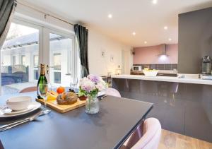 a kitchen with a table with a bottle of wine and flowers at High Trees in Carmarthen