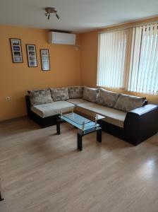 a living room with a couch and a coffee table at Апартамент Родопи in Smolyan