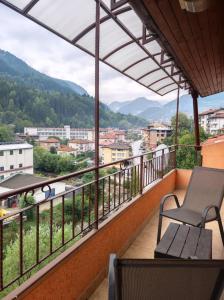 a balcony with a bench and a view of a city at Апартамент Родопи in Smolyan