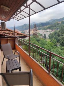 a balcony with a bench and a view at Апартамент Родопи in Smolyan