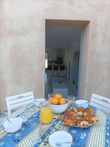 a table with a blue table cloth with food on it at La petite Jarlandine in Château-Arnoux-Saint-Auban