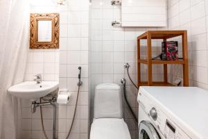a bathroom with a toilet and a sink and a washing machine at 2ndhomes Cozy and Compact studio in Kamppi in Helsinki