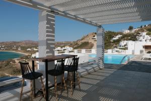 balkon ze stołem i krzesłami oraz basenem w obiekcie Apricot and Sea Luxury Villas w mieście Mikri Vigla