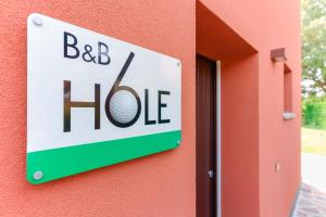 a sign for a bed house on a wall at B&B Hole6 in Castenaso