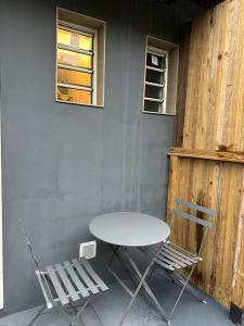 une table et deux chaises assises à côté d'un mur dans l'établissement Studio Détente Route du Maïdo, à Saint-Paul