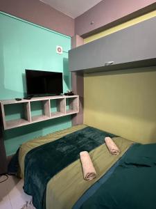 - une chambre avec un grand lit et une télévision à écran plat dans l'établissement Studio Détente Route du Maïdo, à Saint-Paul