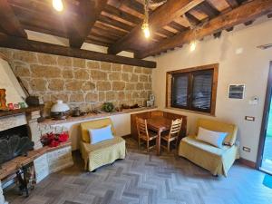 a living room with a fireplace and a table and chairs at Agrifa' in Pitigliano