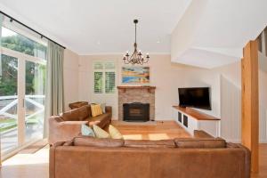 ein Wohnzimmer mit Couch und Kamin in der Unterkunft Apollo Bay Oceanview Mountain Retreat, Pet Friendly, EV station, Fireplace in Apollo Bay + 28 Fotos