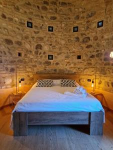 Bett in einem Zimmer mit einer Steinmauer in der Unterkunft Vittoria alla Torre in Pozzolengo