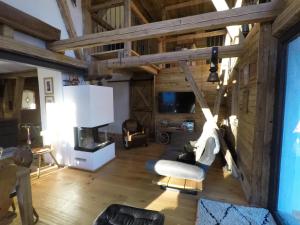 a living room with a couch and a tv at Schönbacher Hof in Hopfgarten im Brixental