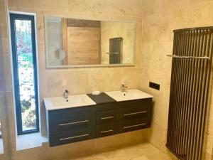 een badkamer met 2 wastafels en een spiegel bij Schönbacher Hof in Hopfgarten im Brixental
