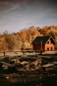 un bâtiment avec une clôture et des bancs devant lui dans l'établissement Osada Krasne - Noclegi Blisko Natury, à Bukowiec