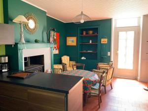 ein Wohnzimmer mit grünen Wänden sowie einem Tisch und Stühlen in der Unterkunft Gite cosy 4 pers en vallée de la Creuse in Baraize