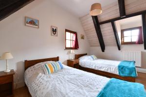 een slaapkamer met 2 bedden en 2 ramen bij Au Nid d'Hirondelles in Ribeauvillé