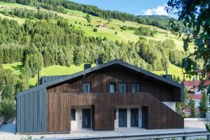 a house in the mountains with a black roof at Appartement1 in San Giovanni in Val Aurina