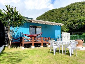 a blue house with a table and chairs in a yard at Koniyado Room 103 - Vacation STAY 42437v in Setouchi